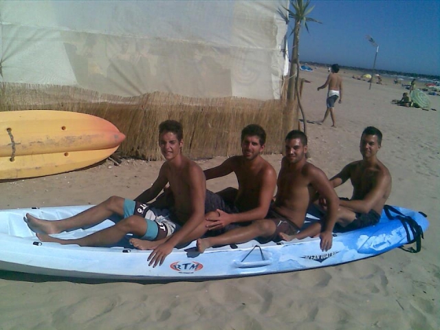 chicos sobre una tabla de surf en la playa